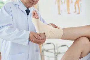 doctor wrapping patient ankle with a bandage 